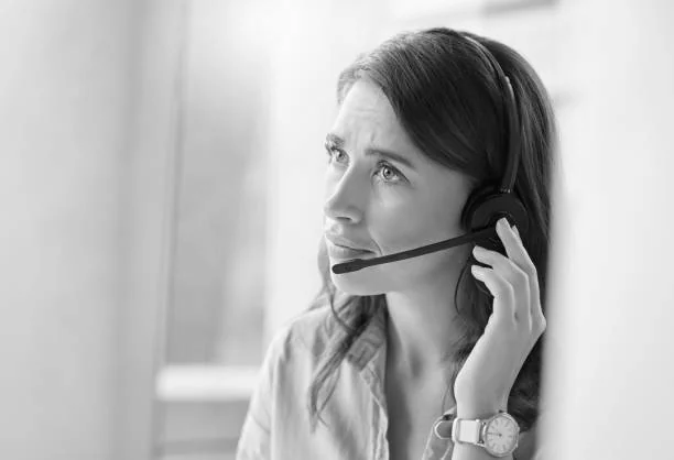 A customer service representative on a headset looking concerned