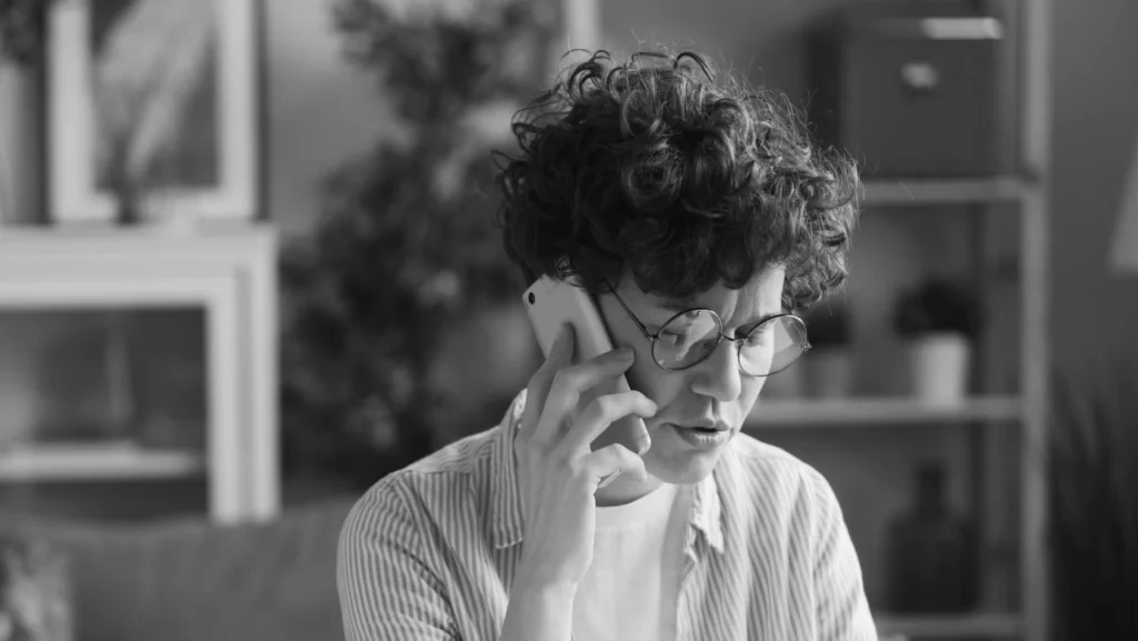 A member on the phone at home, looking frustrated