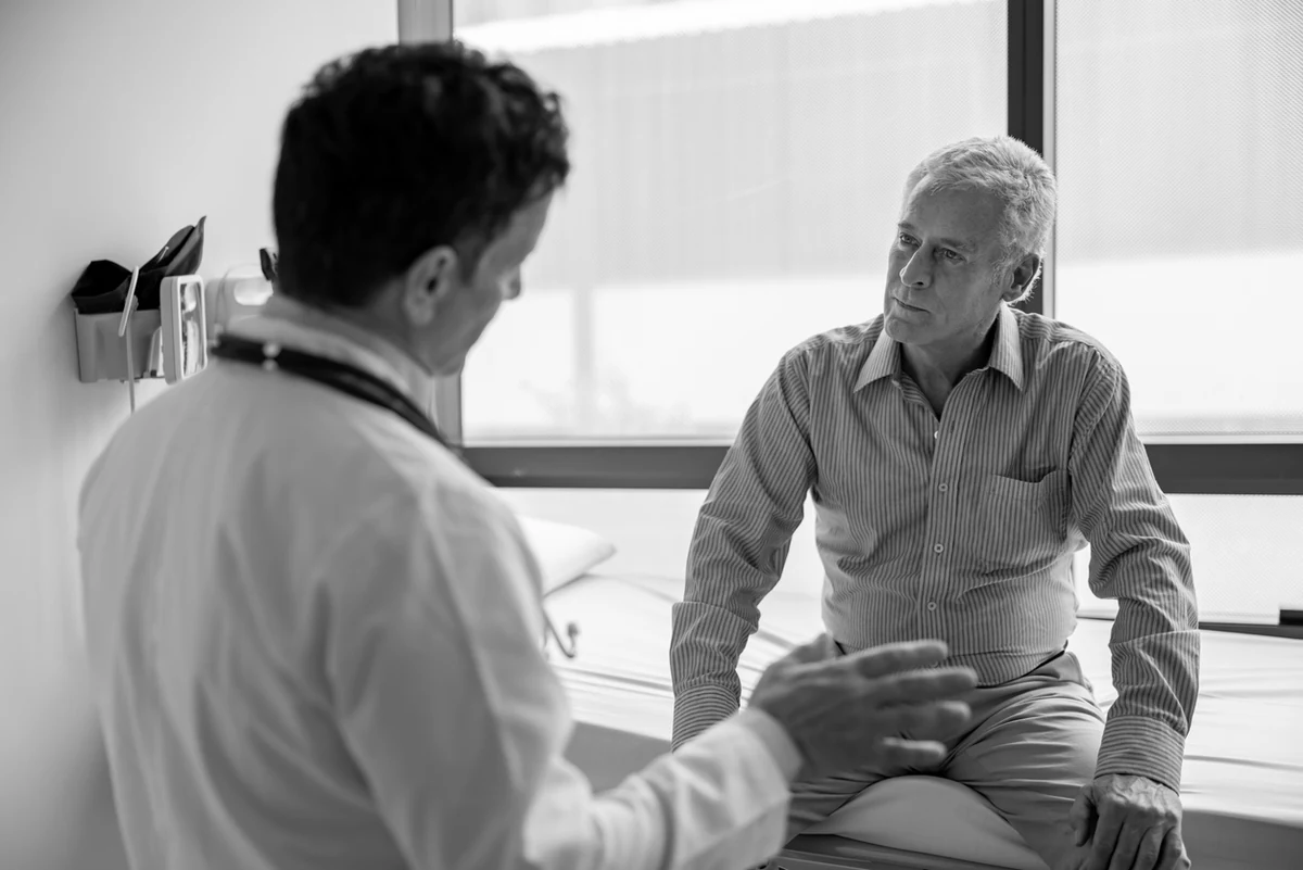 A physician speaking with a patient in a clinic room